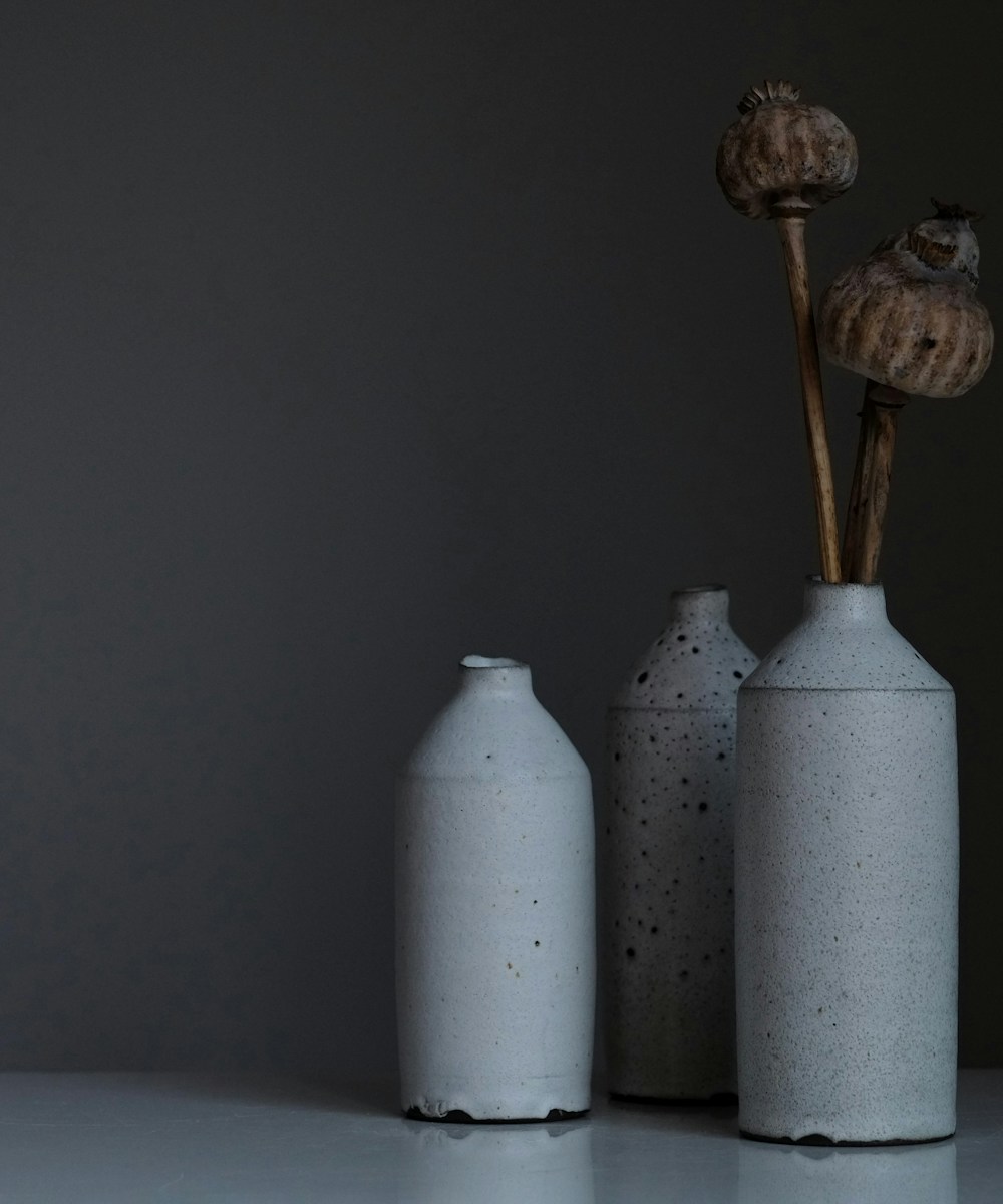 Céramiques d'atelier vallaurisien, trio de bouteilles émaillées sur fond gris, signature du village Métiers d'Art